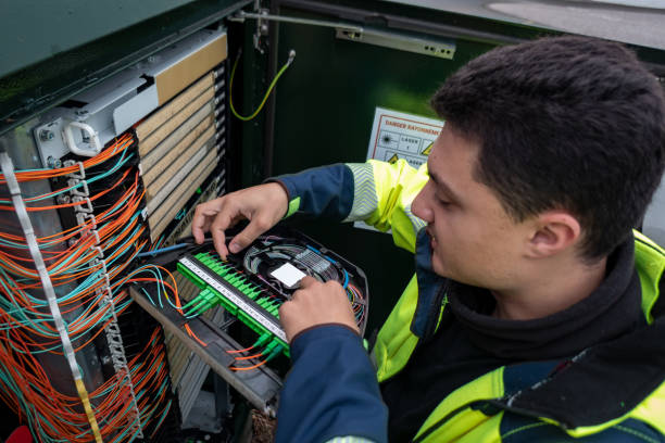 Fiber optic technician performing repairs on a cabinet